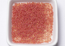 Бисер Чехия круглый 10/0 50г 11396 прозрачный светло-янтарный с розовым прокрасом (кораллово-красный, розоватый)